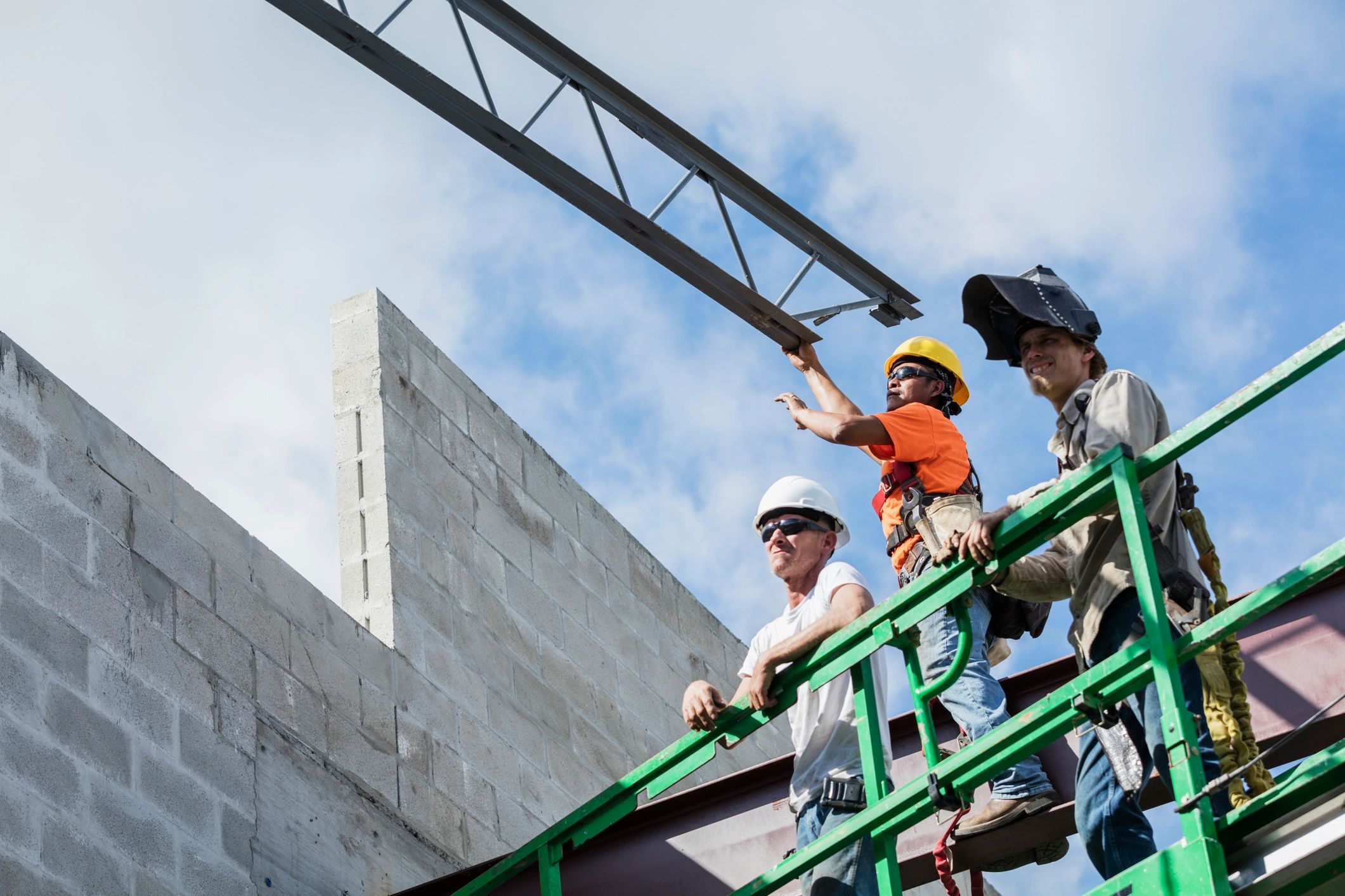 Ironworkers installing a roof joist at a construction site