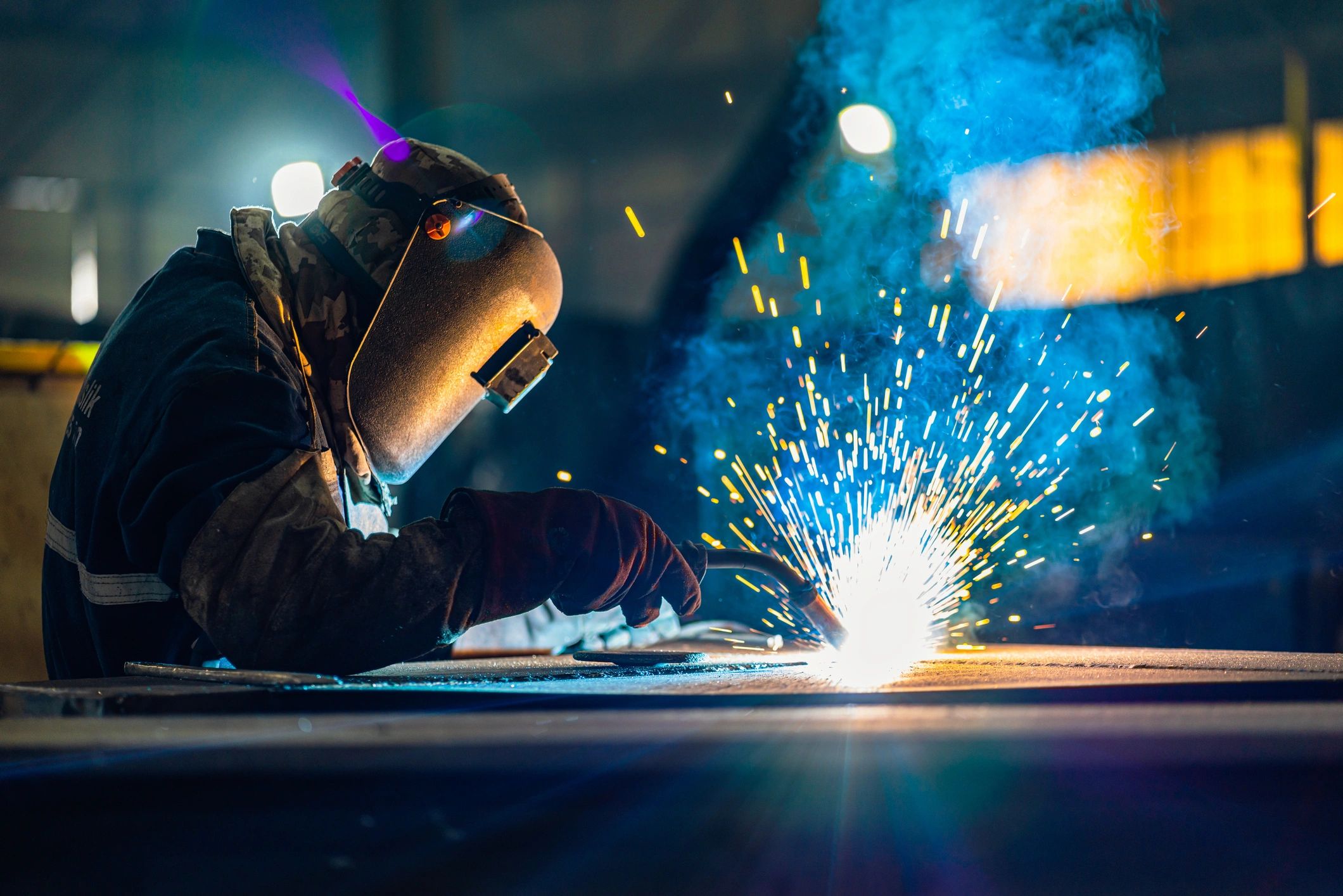Welder fabricating steel components in a workshop