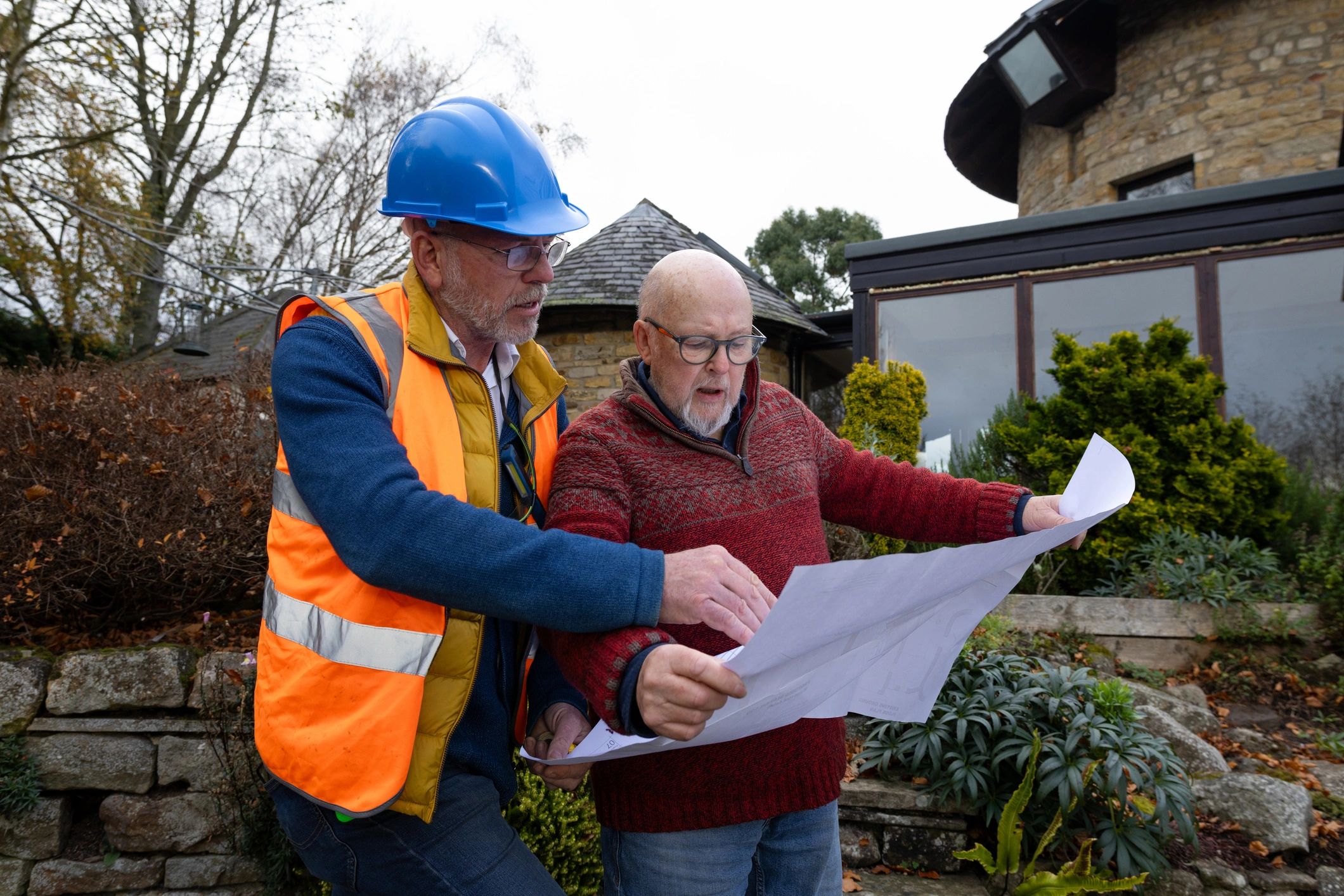 Contractor and client reviewing blueprints on site