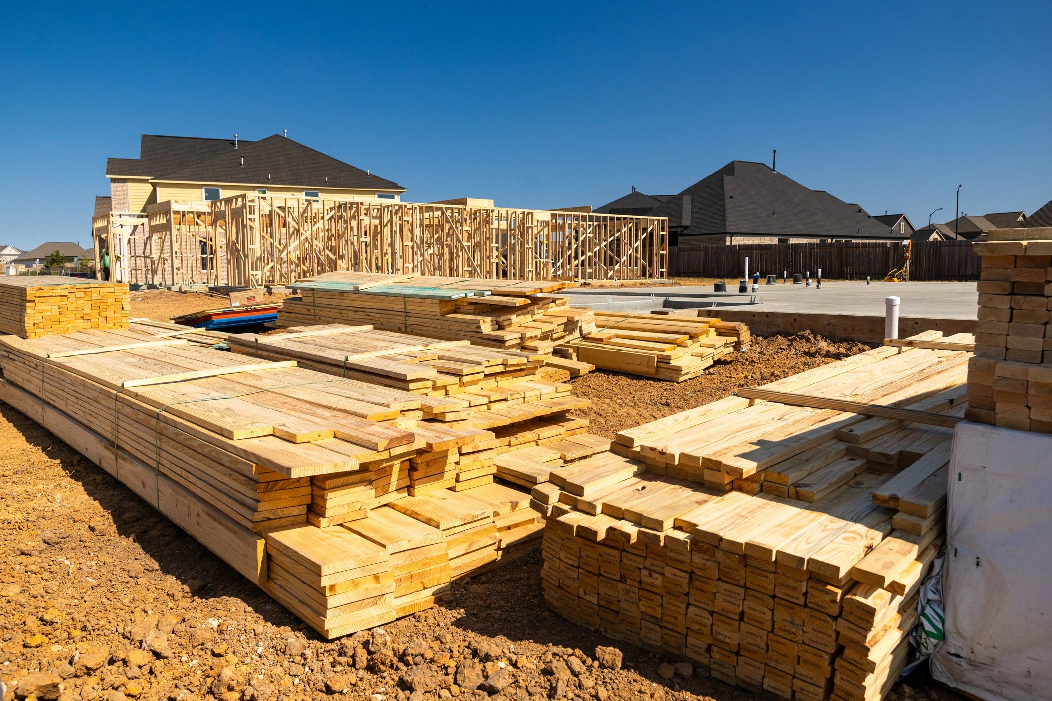 Construction materials staged beside a new foundation
