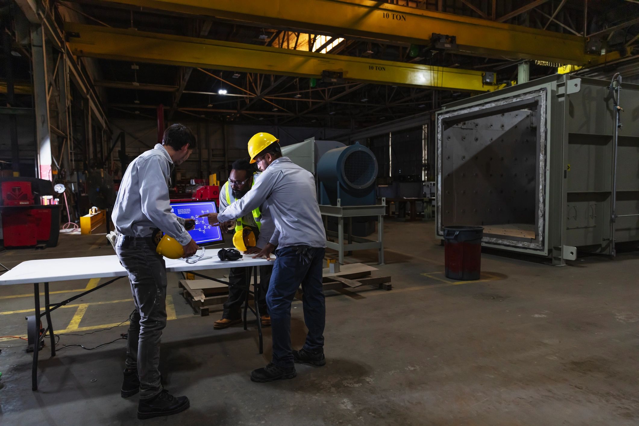 Manufacturing workers reviewing a diagram on a factory floor
